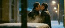 Couple sharing a tender kiss on a snowy winter evening