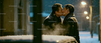Couple sharing a tender kiss on a snowy winter evening