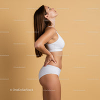Elegant Woman in White Sportswear Relaxing in Neutral Studio Background