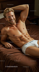 Smiling fit man relaxing on bed in white underwear