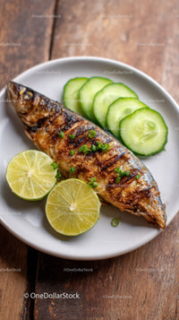 Grilled Mackerel Fish with Cucumber and Lime Garnish on White Plate