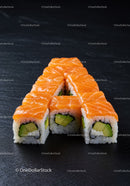 Fresh salmon avocado sushi rolls arranged on black slate