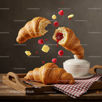 Fresh croissants with raspberry jam and butter cubes