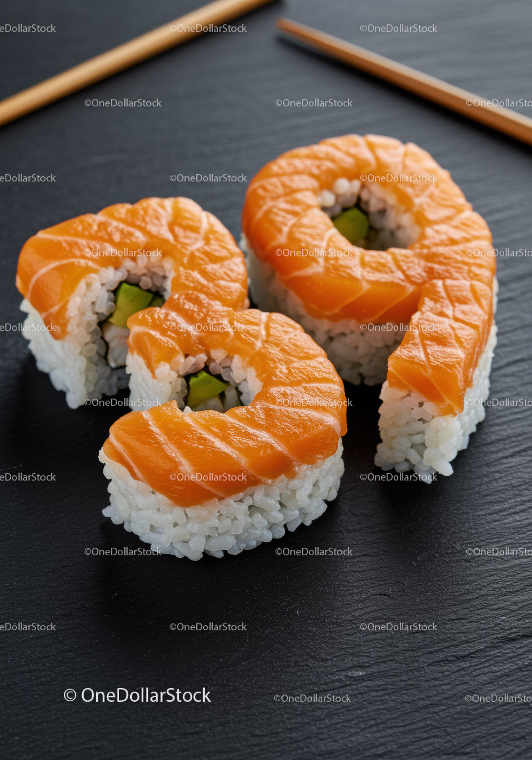 Świeże rolki sushi z łososiem i awokado na czarnym talerzu łupkowym