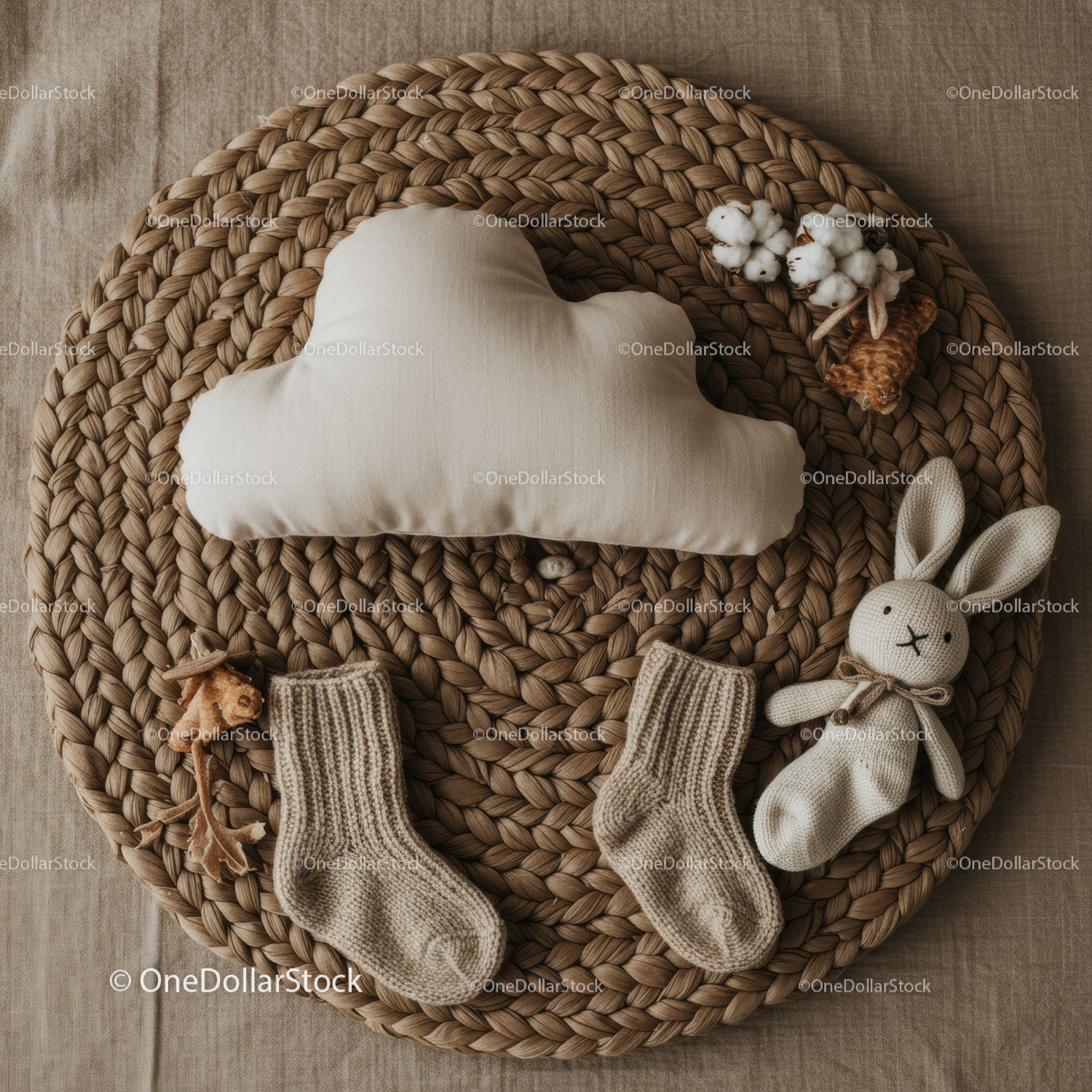 Cozy neutral baby items arranged on woven mat
