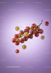 Fresh red grapes with water splash on purple background