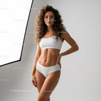 Elegant Young Woman in White Sportswear with Curly Hair posing