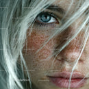 Close-up of Blue Eyes and Freckled Skin on Woman with White Hair