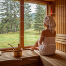 Serene Woman Relaxing in Wooden Sauna with Scenic Forest View