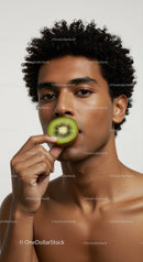 Young Man Holding Fresh Kiwi Fruit Close-Up Portrait