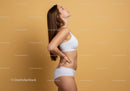 Young Woman with Toned Physique in White Sportswear on Beige Background