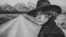 Black and White Portrait of Woman Wearing Wide-Brimmed Hat in Outdoors