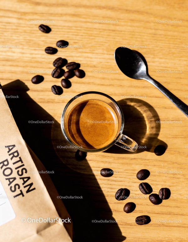 Fresh espresso with artisan coffee beans on wooden table