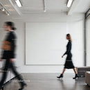 Blurred motion of two women walking in minimal gallery space
