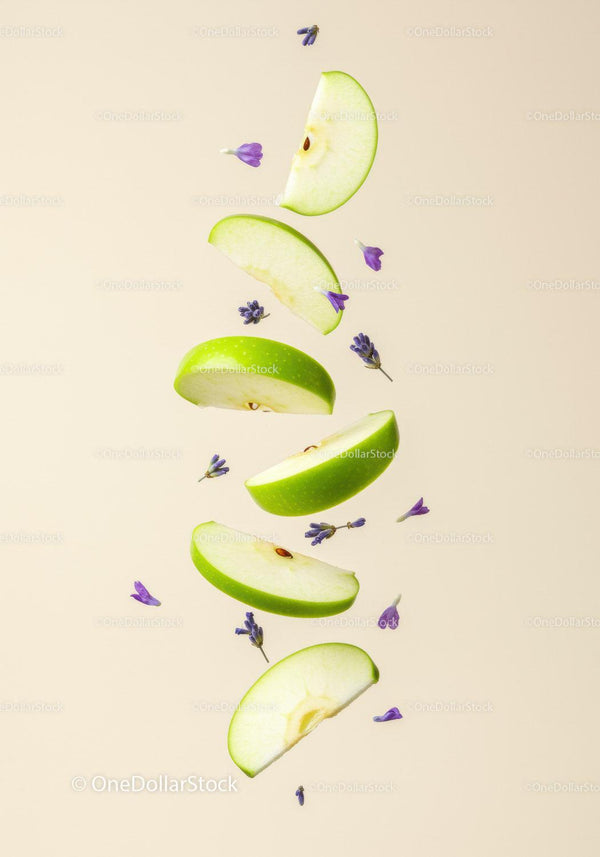 Sliced green apple with floating lavender flowers