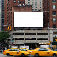 Busy city street with yellow taxis and blank billboard