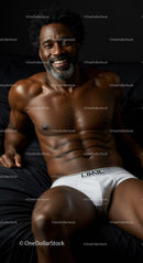 Smiling muscular man relaxing on black bed in white underwear