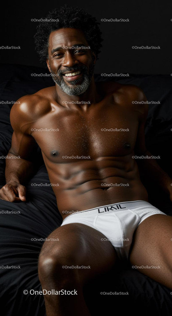 Smiling muscular man relaxing on black bed in white underwear