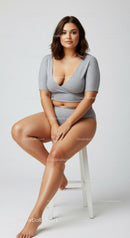 Confident Young Woman Sitting on Stool in Stylish Casualwear
