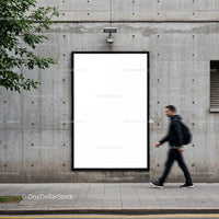 Urban man walking past blank vertical billboard on wall