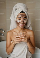 Young Woman With Facial Mask Enjoying Spa Session In Bathroom