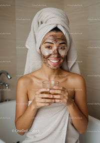 Young Woman With Facial Mask Enjoying Spa Session In Bathroom