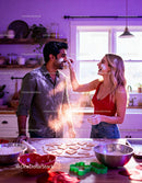 Couple playfully baking heart shaped cookies together