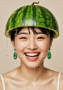 Smiling woman wearing watermelon helmet with water droplets