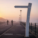 Early Morning Cyclists on Misty Waterfront Path
