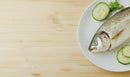Fresh Whole Fish with Cucumber Slices on White Plate for Seafood Cuisine