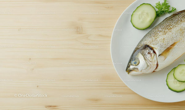 Fresh Whole Fish with Cucumber Slices on White Plate for Seafood Cuisine