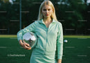 Young woman in mint green athletic outfit holding disco ball outdoors