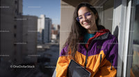 Young Woman Smiling with Tablet on Balcony Overlooking City Skyline
