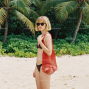 Woman in Bikini with Red Tote Bag on Tropical Beach with Palm Trees
