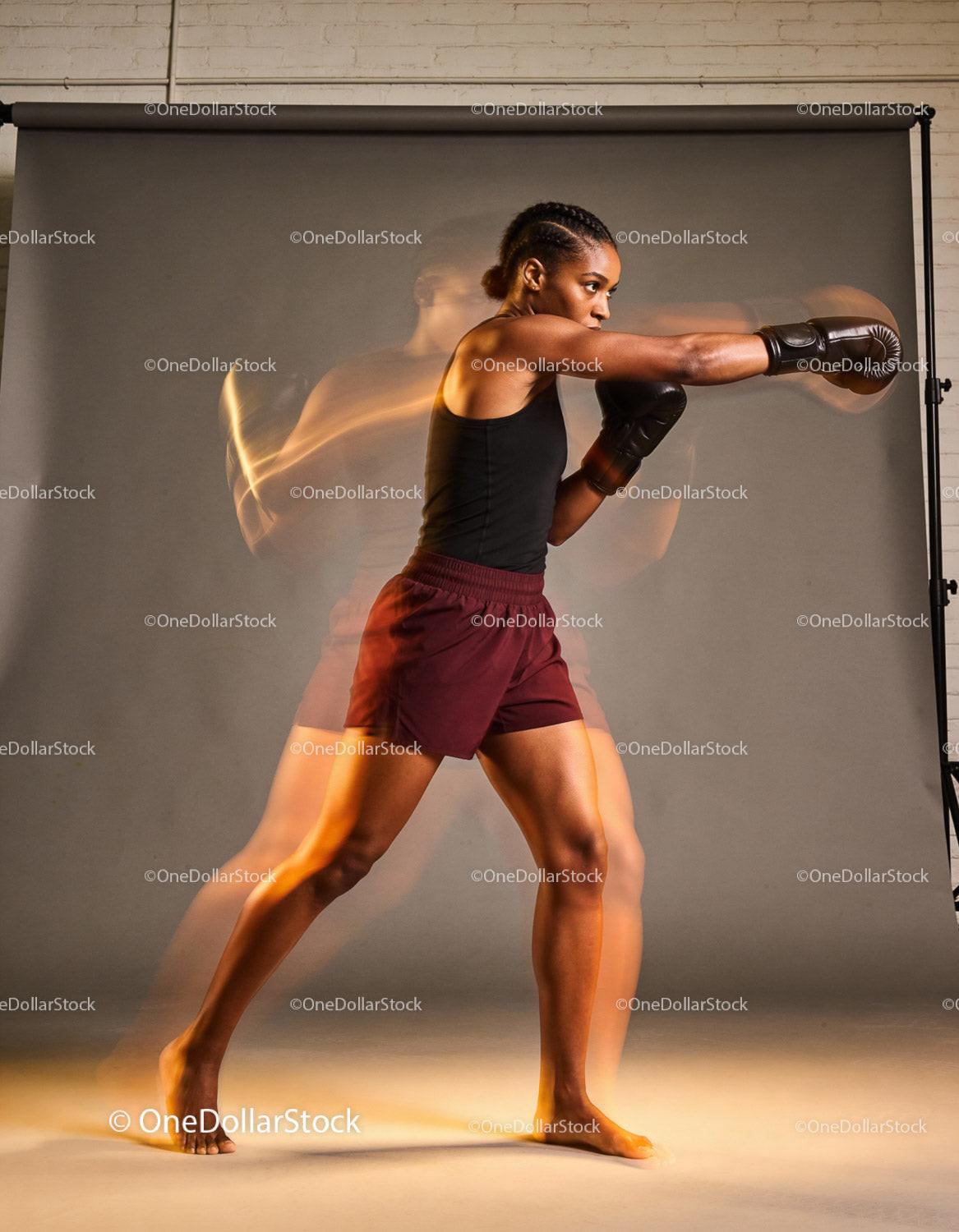 Focused woman throwing a powerful punch in boxing training