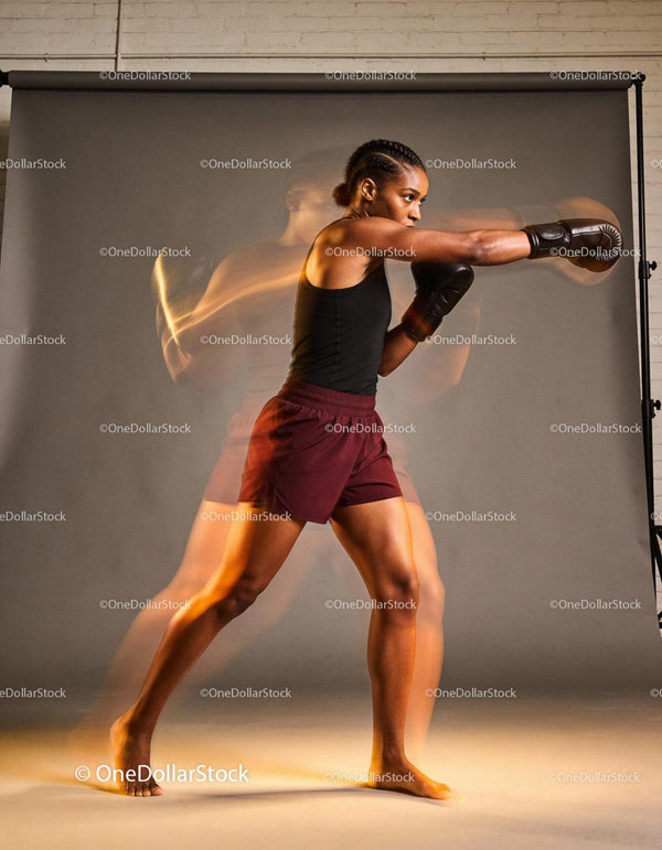 Focused woman throwing a powerful punch in boxing training