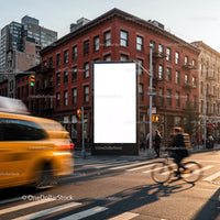 City street intersection with blank billboard and traffic