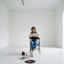 Young woman listens to vinyl music in minimalistic room