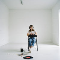 Young woman listens to vinyl music in minimalistic room