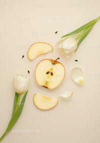Fresh apple slices with white tulips on beige background