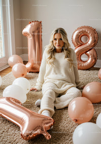 Young woman celebrating 18th birthday with balloons indoors