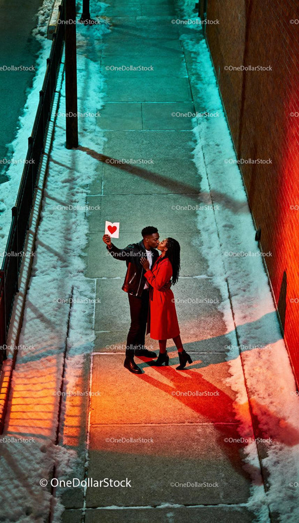 Couple Sharing Romantic Kiss on Snowy Urban Sidewalk