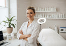 Female Healthcare Professional Standing in Medical Clinic with Treatment Bed