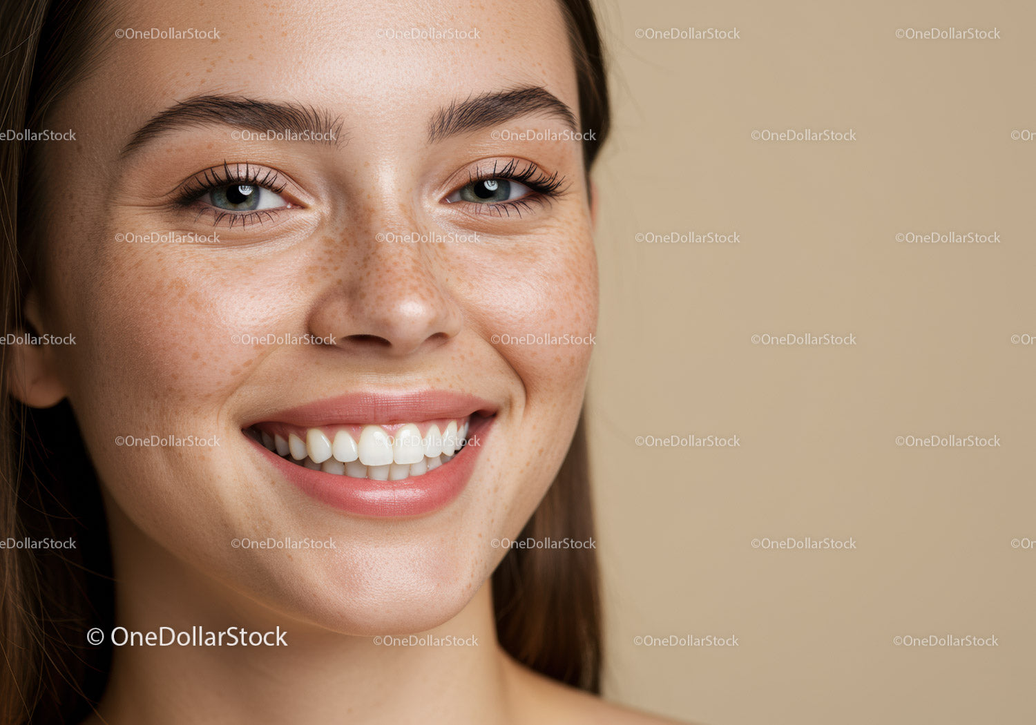 Close up of smiling young woman with freckles and blue eyes