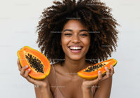Happy Woman with Curly Hair Holding Juicy Papayas in Bright Studio