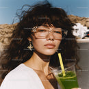 Young Woman with Curly Hair Wearing Sunglasses and Drinking Green Smoothie
