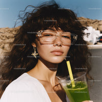 Young Woman with Curly Hair Wearing Sunglasses and Drinking Green Smoothie