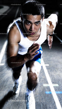 Focused male sprinter pushing off during intense night training