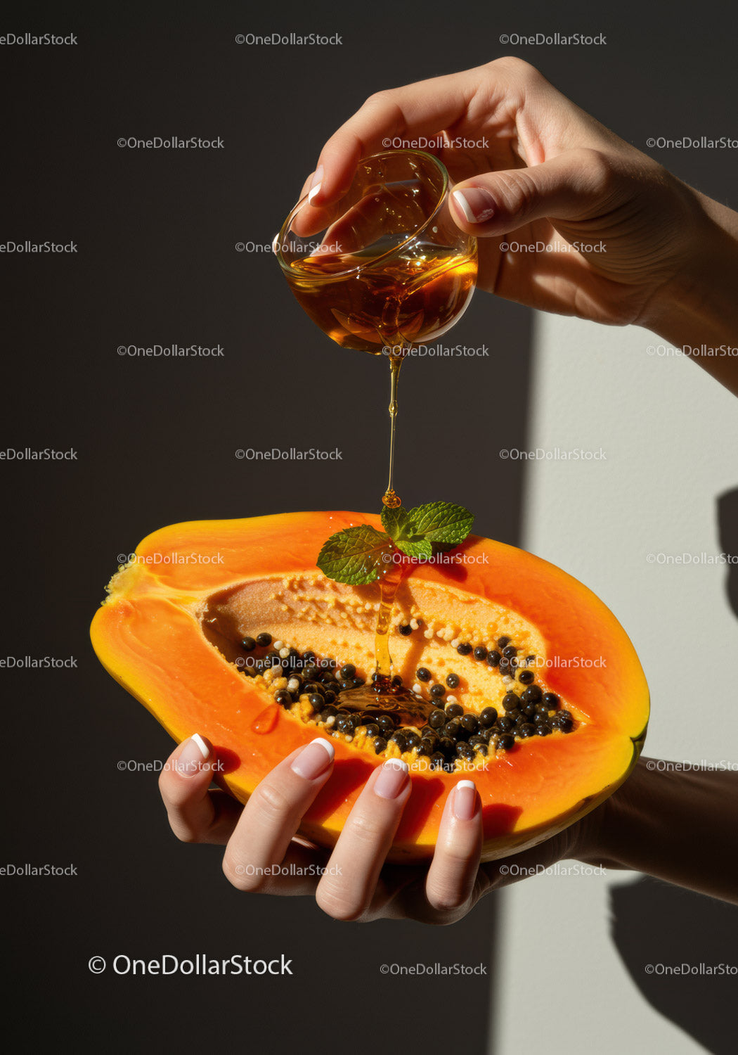 Pouring honey over fresh papaya with mint garnish