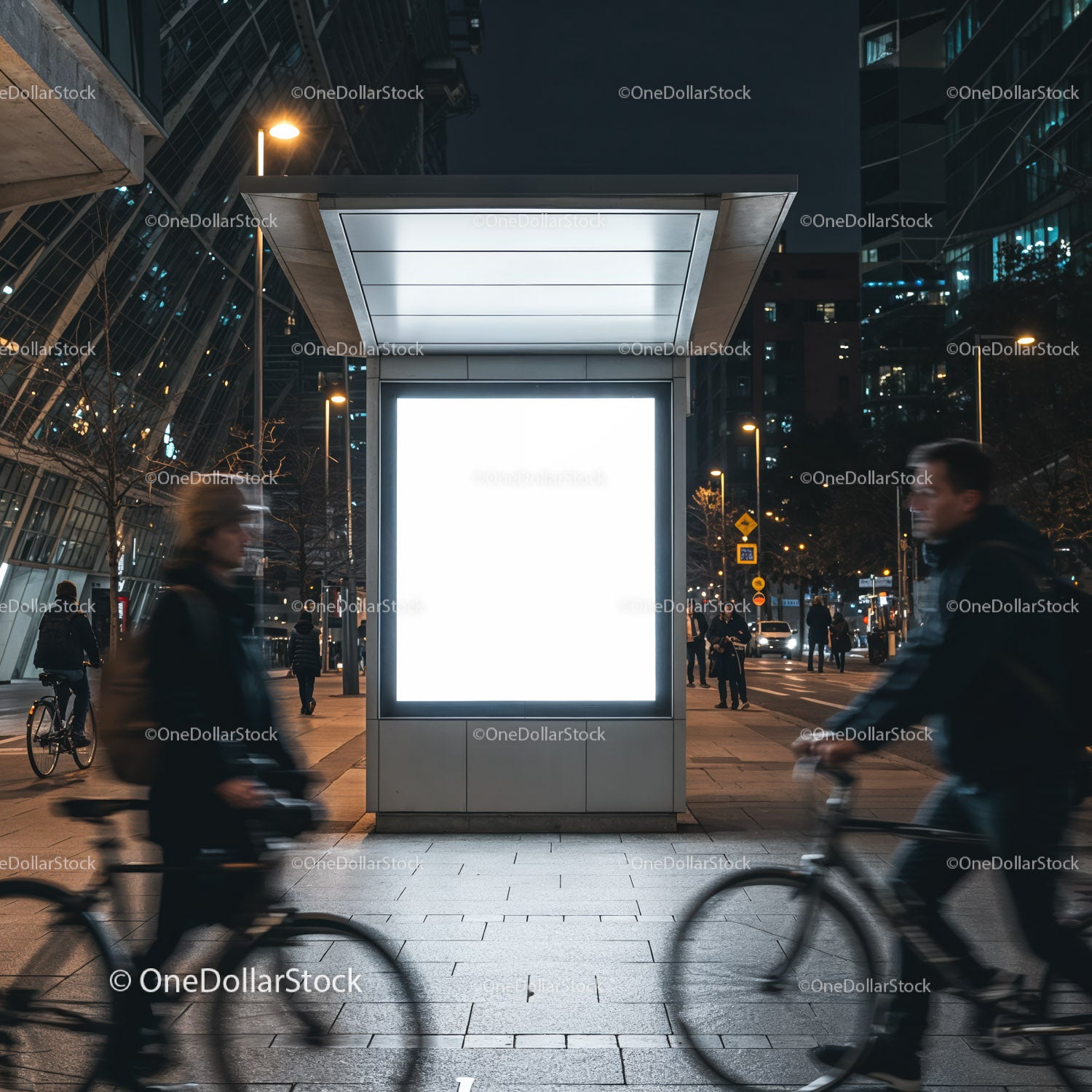 Nocny widok miasta z niewyraźnymi rowerzystami przejeżdżającymi obok billboardu